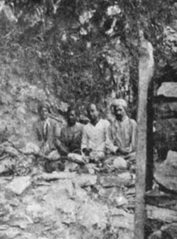 One of the caves occupied by Babaji in the Drongiri Mountains near Ranikhet in the Himalayas. A grandson of Lahiri Mahasaya, Ananda Mohan Lahiri (second from right, in white), and three other devotees are visiting the sacred spot.