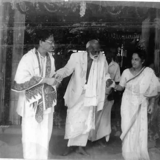 Sri Ramaswami Pillai is being brought from his room to the Sacred Shrine of SRI BHAGAVAN on SRI BHAGAVAN's JAYANTHI day -- by Anuradha and Ganesan, supporting Sri Pillai by holding his hands. He had already completed and crossed over 100 years of age ! When he reached the Shrine, he sat ( exhausted ) on the steps of the Shrine (which except for the priests no one is permitted ) . The priests were chanting. Sri Pillai majestically turned back to the Linga and in his stentorian voice prayed aloud : " Varumbadi Solilai Vandhu Yen Padi Ala " = " Did You not Command me to come ? NOW, take me ENTIRELY into Your fold ! " Very soon, Sri Pillai consciously died, after asking the servant make him sit on his bed cross-legged and loudly chanting SRI BHAGAVAN's " Marital Garland of Letters " ! What a powerful prayer by the devout disciple and how the Great GURU -- RAMANA -- fully responded to it by absorbing him into HIS FOLD !