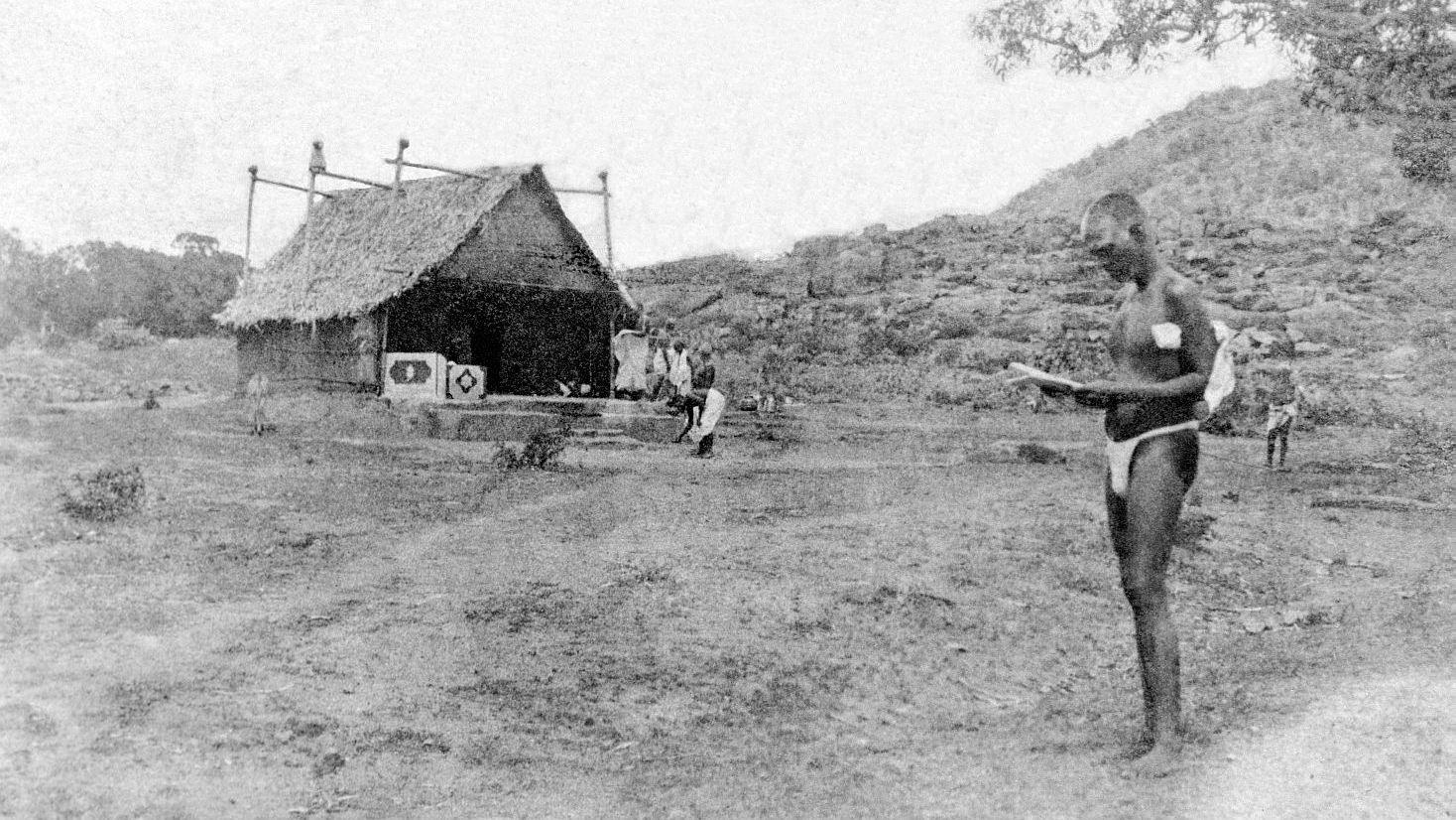 Earliest known photograph of Ramanasramam. Bhagavan seen reading a letter.