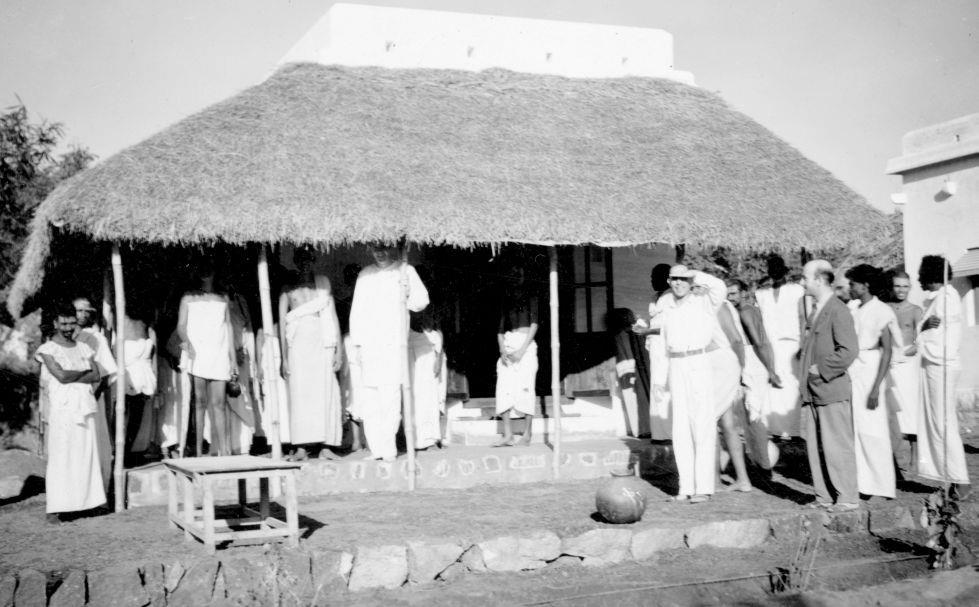 Sri Bhagavan ( head hidden) at the house-warming ceremony of Chadwick’s cottage. S. S. Cohen (with left hand covering his eyes) and Paul Brunton are also seen.