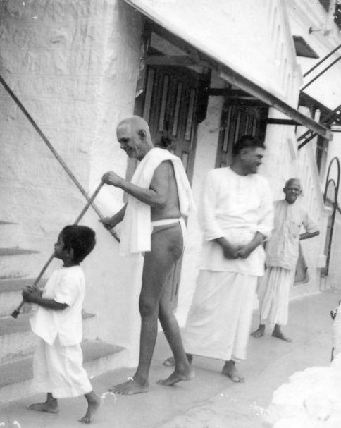 Sri Bhagavan is all joy being led by a playful child into the dining hall