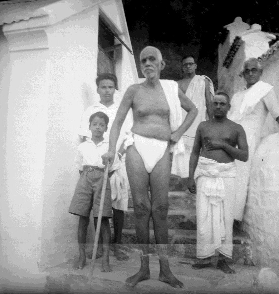 Sri Bhagavan at ‘Skandashram’ ( Doraiswamy Iyer is on His left, leaning on the wall)