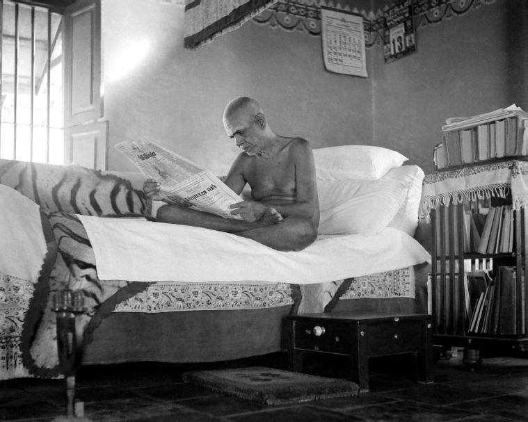 Sri Bhagavan in the ‘Old Hall’. Notice His reference library on wheels, next to Him.