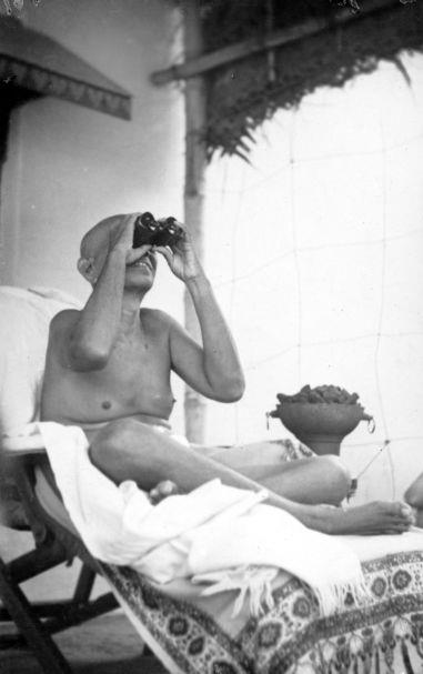 A rare photo of Sri Bhagavan looking at the Hill through binoculars