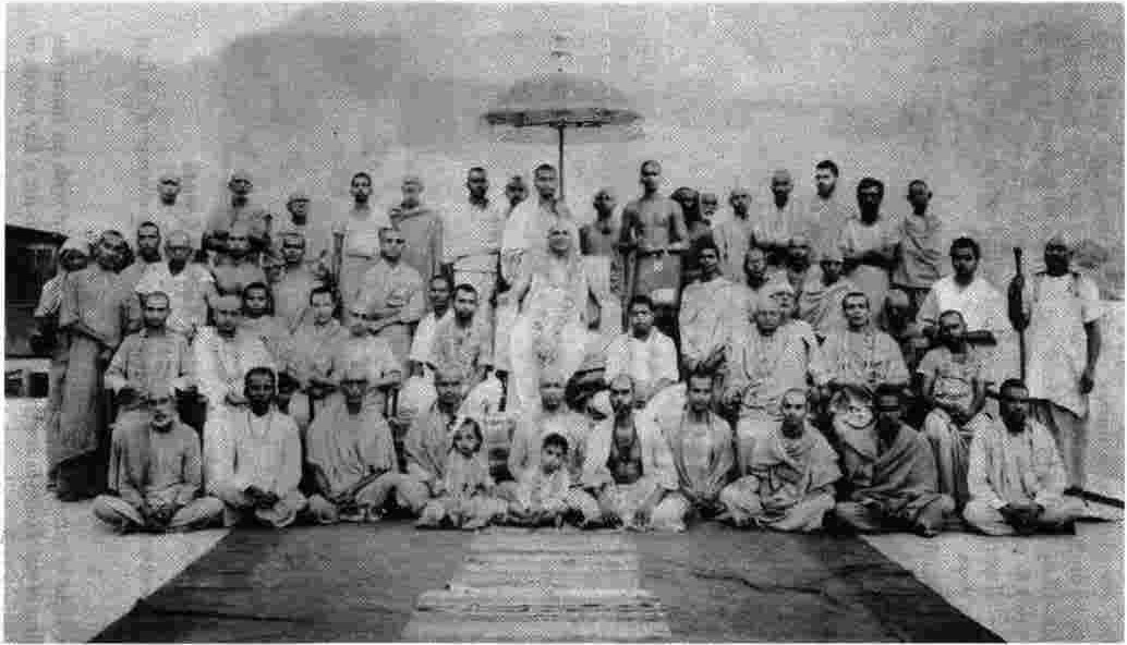 A unique photo of Swamiji with some of his close disciples. Holding the umbrella is Swami Venkatesananda. Seated on chairs are Swamis Madhavananda (2nd from left), Krishnananda (3rd from left), Chidananda (2nd from right), Vishnudevananda (far right), while standing next to Swami Vishnudevananda is Swami Paramananda. Swami Nadabrahmananda is seated in front of Swami Sivananda.