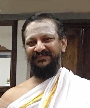 photo of a bearded man with vibhuti marks, wearing a white shawl with gold border (beside the Foreword text)