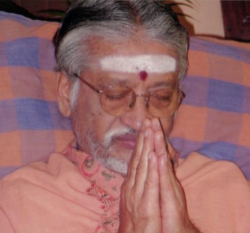 photo of an elderly man with vibhuti on forehead, eyes closed, hands folded in prayer (left of the opening paragraphs)