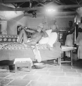 photograph: Sri Bhagavan reclining on couch inside the Old Hall