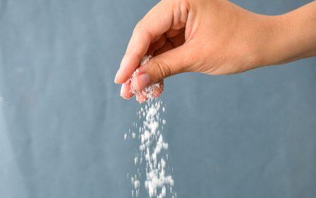 photo of a hand dropping a pinch of salt