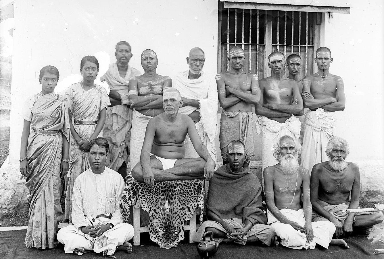 group photograph outside the Old Hall with Sri Bhagavan seated among devotees