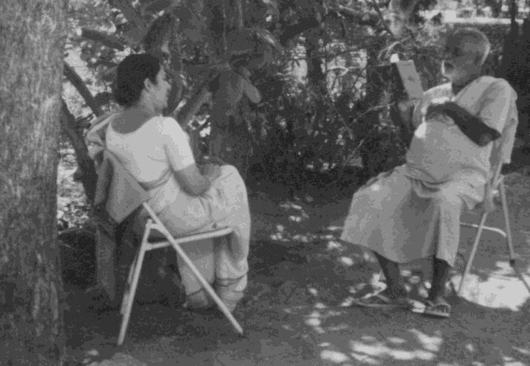 photo of Kunju Swami seated outdoors with Anuradha