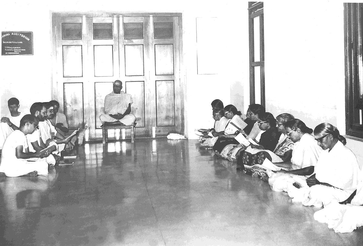 photo of Tamil Parayanam group seated on floor in hall, Kunju Swami on stool in centre