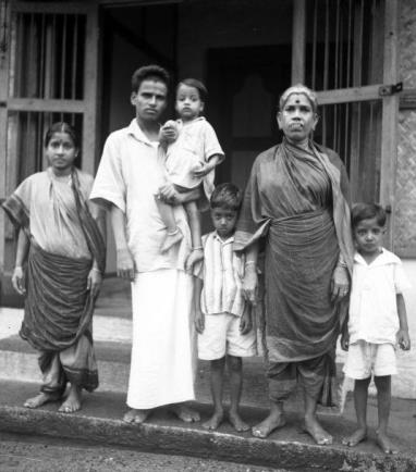 family standing in a doorway, a man carrying a child