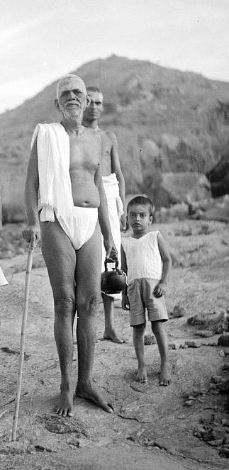 Sri Bhagavan standing with staff, a boy beside him