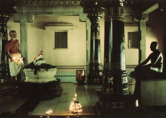 interior of shrine with lamp-lit lotus pedestal and seated statue