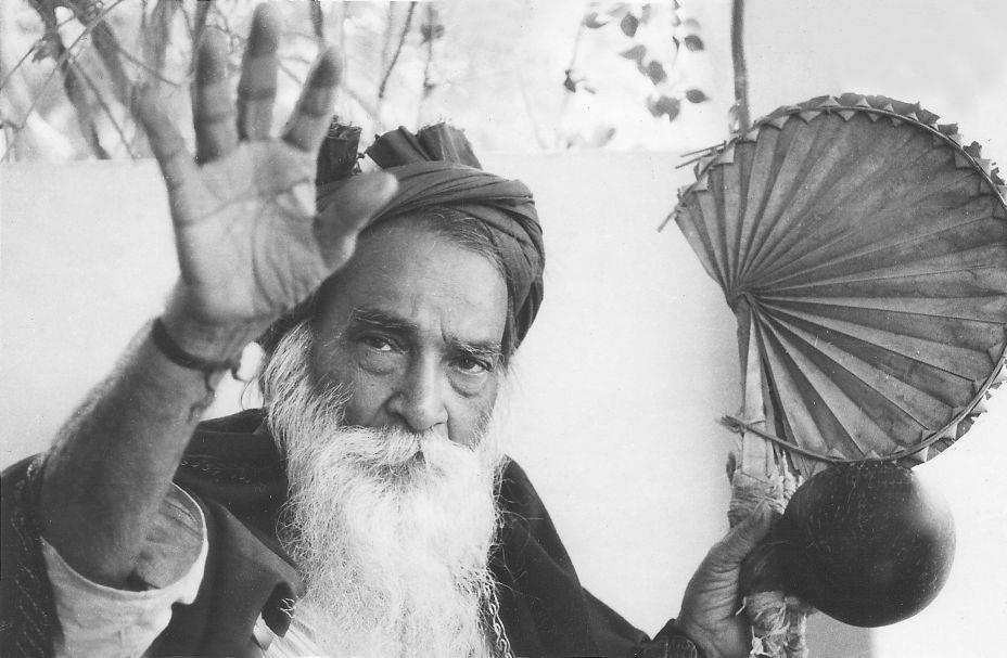 Yogi Ramsuratkumar raising a hand, black-and-white