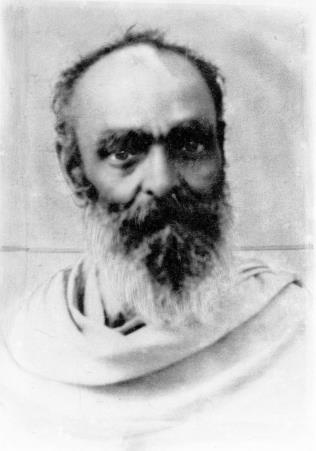 black-and-white portrait of a bearded bald man in a shawl (unnamed), text wraps to its right; no caption
