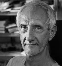 portrait photo of elderly man with bookshelf behind