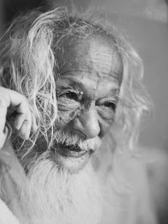 portrait photo of old man with long white hair and beard