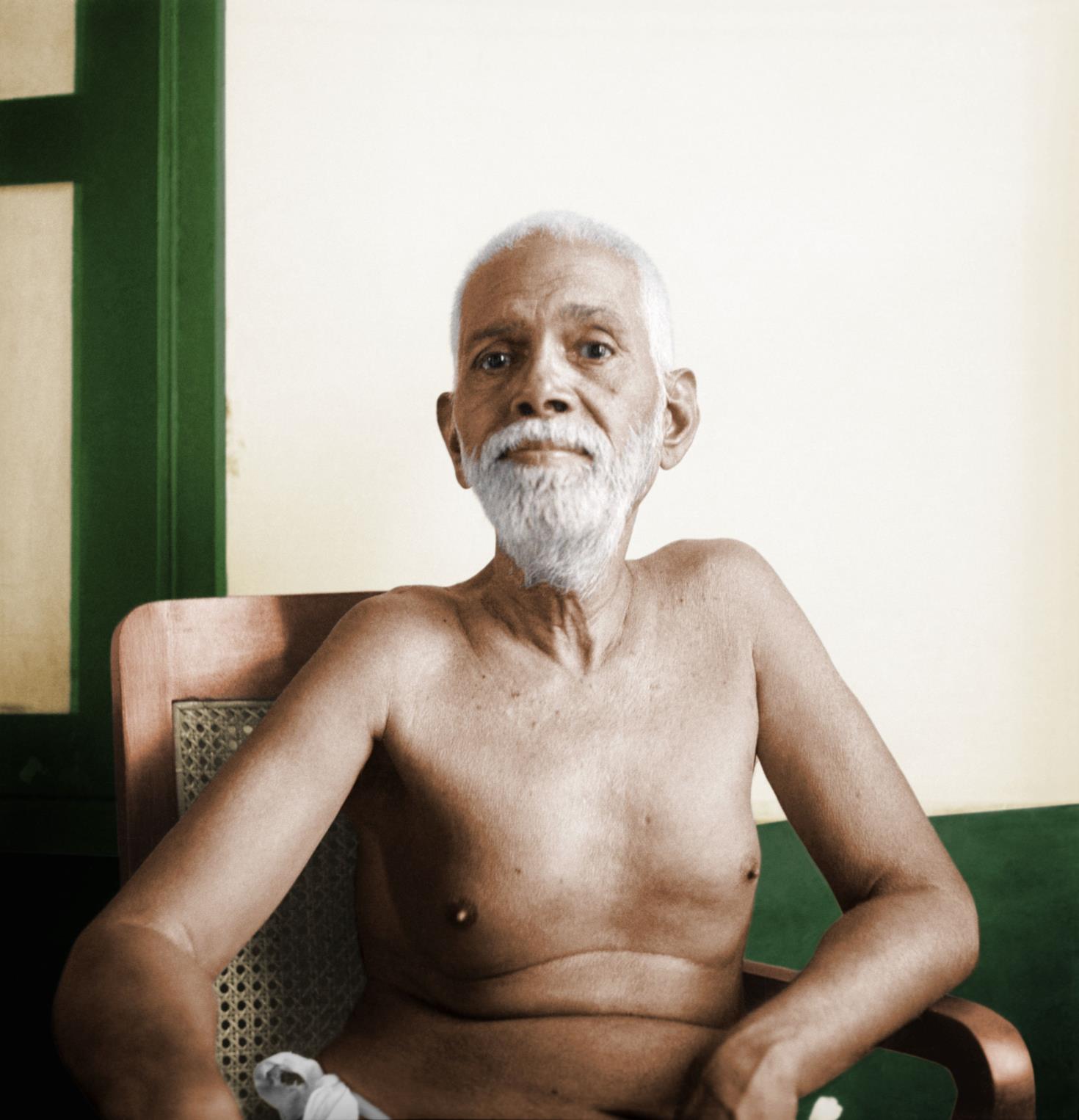 full-page colour photo of Sri Bhagavan seated in a cane chair, white-bearded