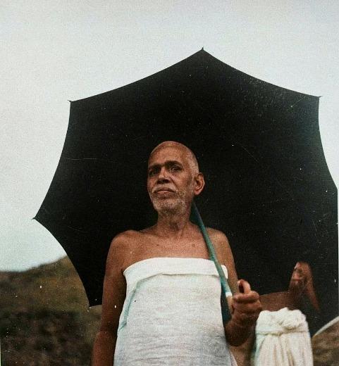 photo of Sri Bhagavan standing under a black umbrella
