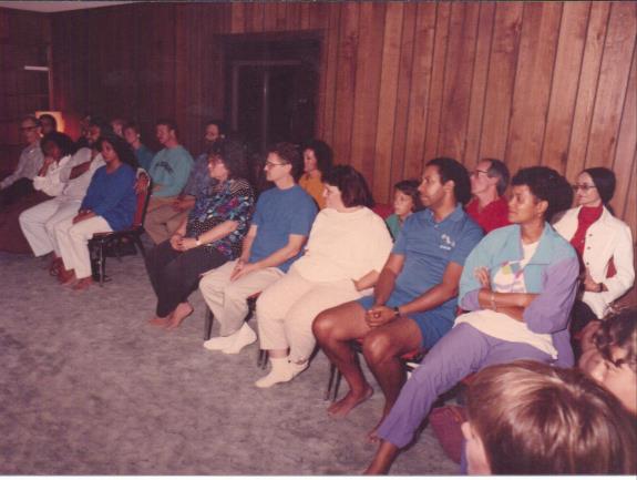 photo of devotees seated listening to a talk