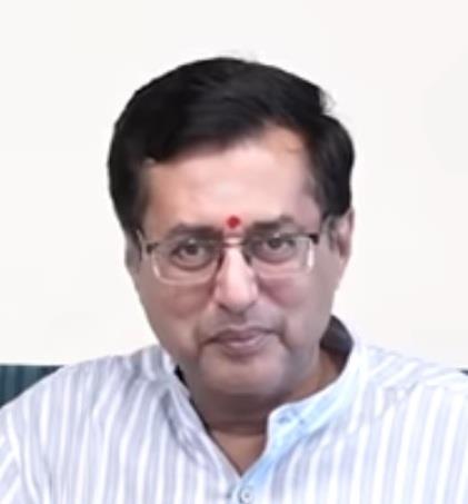 portrait photo of Dr. Anand in striped shirt